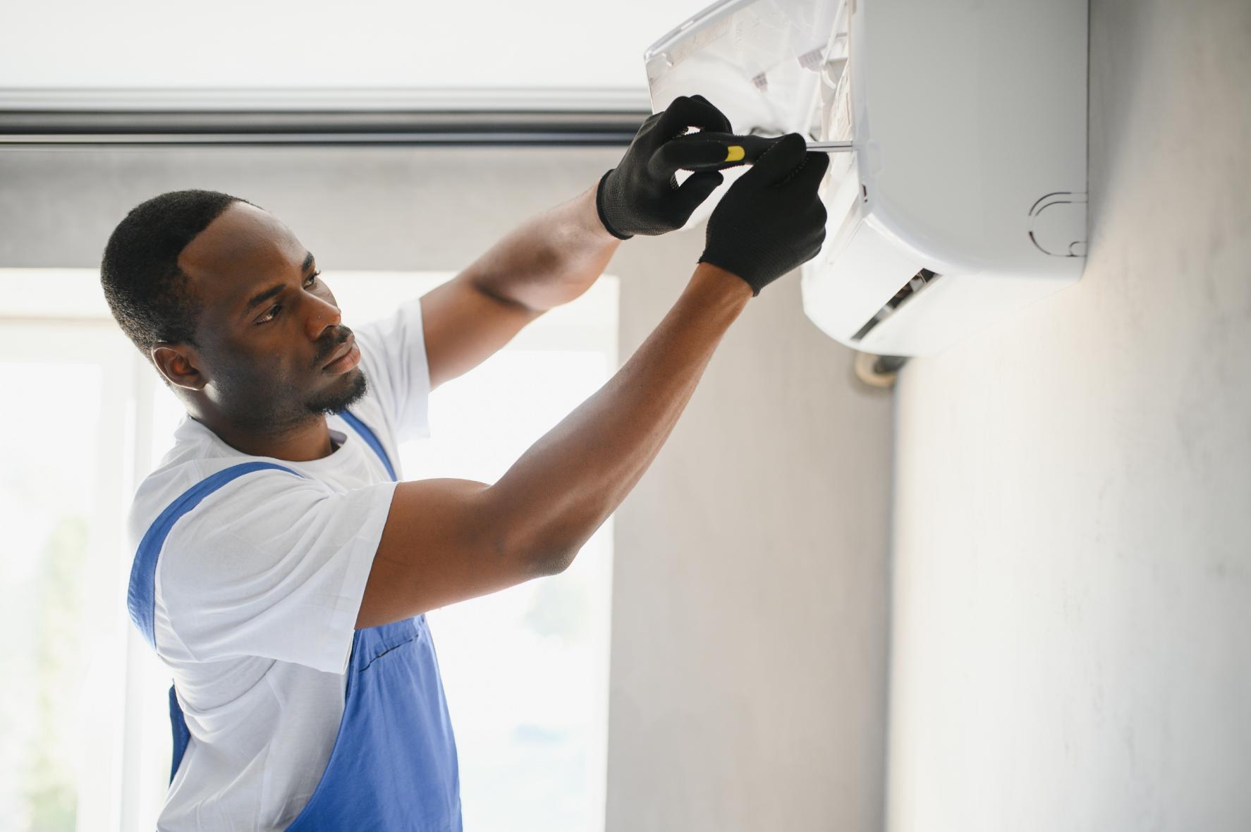 Experienced HVAC technician performing indoor air conditioning unit installation and repair
